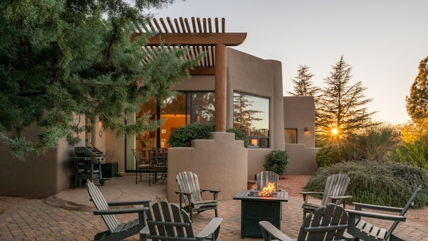 An outdoor patio with Adirondack chairs, a fire pit, and a pergola. - Luxury West Sedona home close to everything (Sedona)