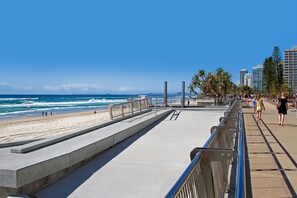 Stroll along the oceanfront promenade with a clear view of the sandy beach.