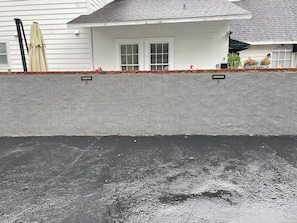 A white building with a grey wall in the foreground, a 'RESERVED' sign, and a black surface below. - Private, beautiful apartment in historic district (Ocala)