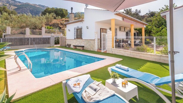 A swimming pool with lounge chairs and a covered patio area.