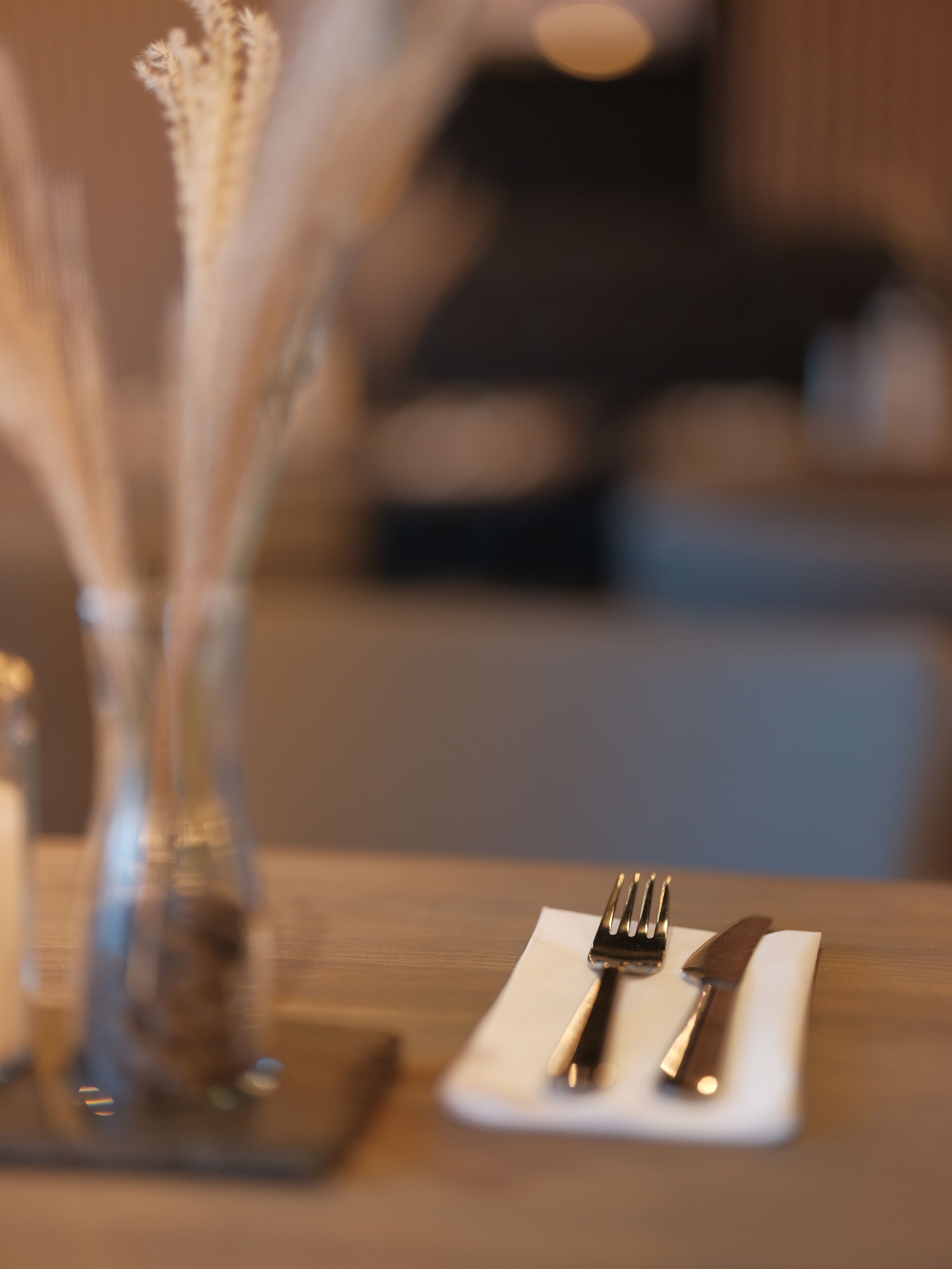 A dining table with a white napkin, a fork, and a knife.