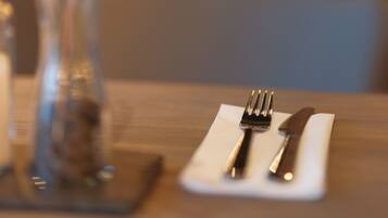 A dining table with a white napkin, a fork, and a knife.