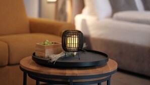 A modern living room with a round wooden coffee table, a black wireframe lamp, and a wooden box with grapes. - THE ROOMS - Hotel & House (Frankfurt)
