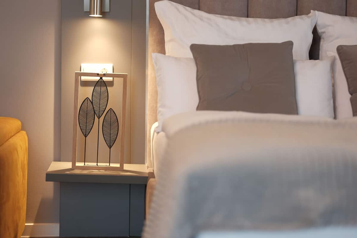 A modern bedroom with a bed, bedside table, and decorative wall art.