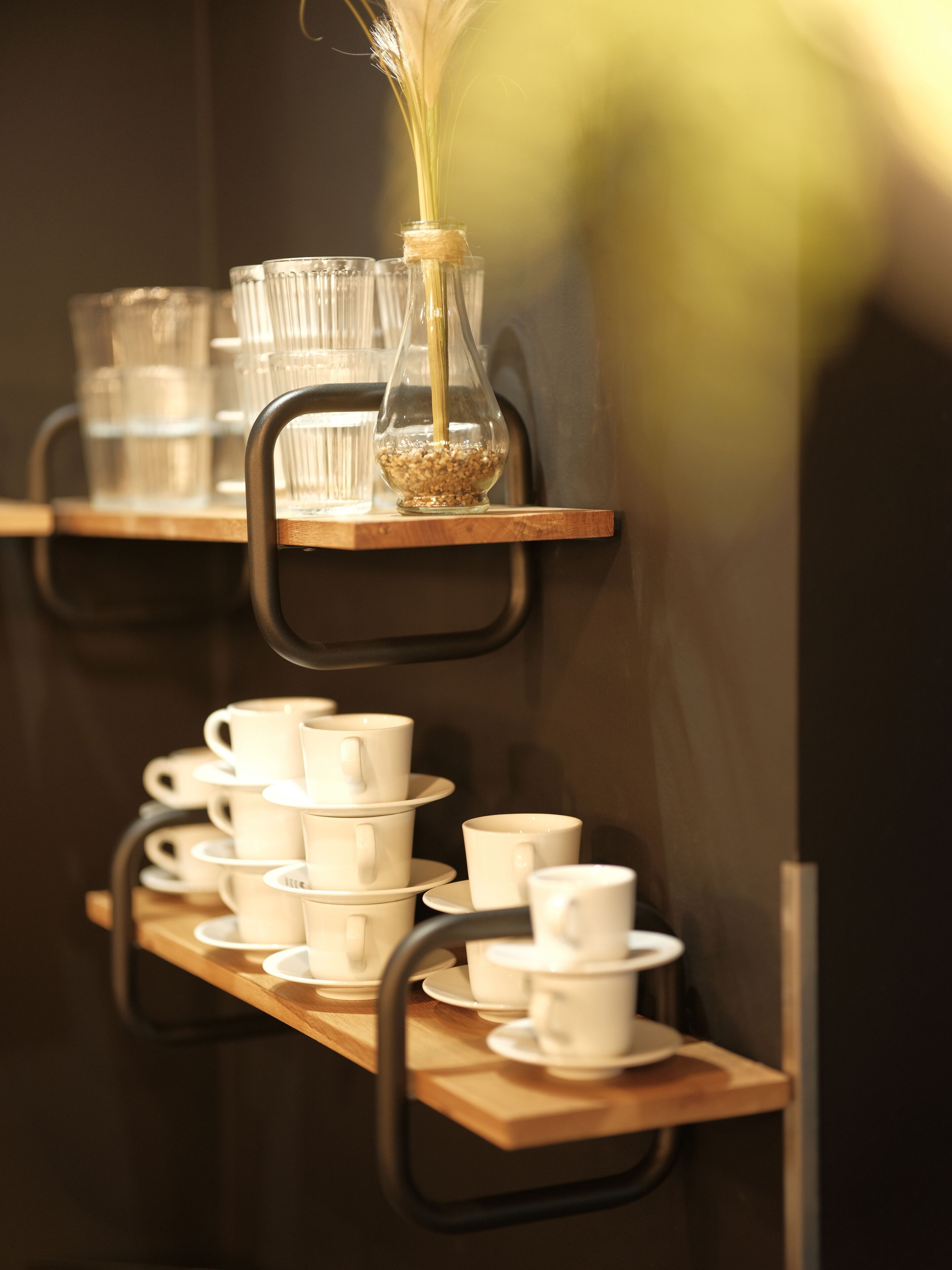 A display of white cups and saucers on wooden shelves.