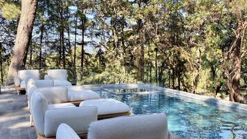 Zona junto a la piscina con mobiliario moderno y vista despejada.