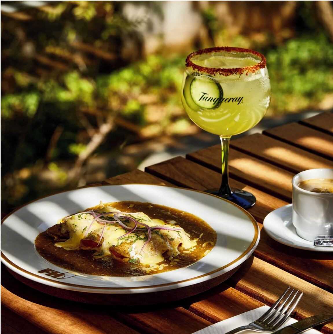 A meal with a glass of Tangyay and a cup of coffee on a wooden table.