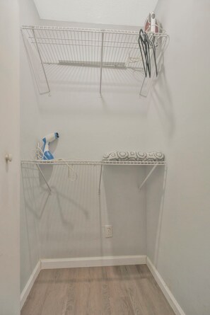 A small, enclosed space with a ceiling fan, a metal shelf, and a blue spray bottle. - Perfect Pensacola Getaway Near Beaches & Downtown! (Pensacola)