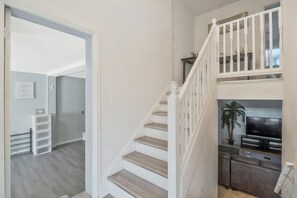 Eine Treppe mit weißen Balustraden, die zu einer Zwischenebene führt.