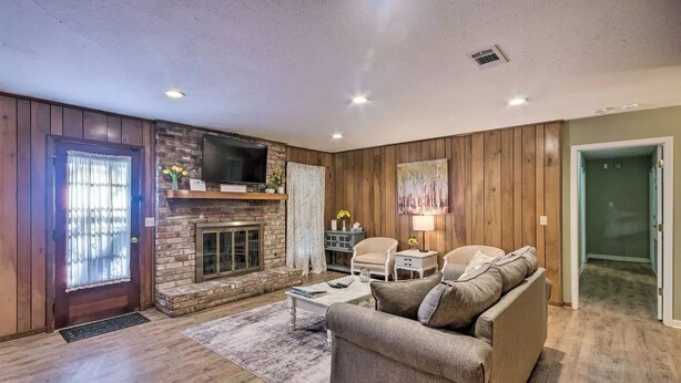 A living room with a fireplace, wooden walls, a sofa, and a television. - Peaceful Home, Colleges-Hospitals-Shops Close, Corporate Bookings Welcome  (Jackson)