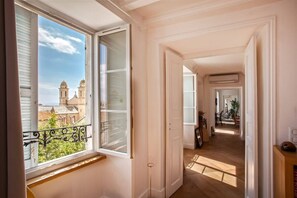 A corridor with a view of a church through an open window. - Le Saint-Jean (Bastia)