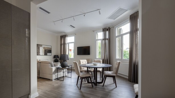 A modern living room with a dining area, large windows, and a flat-screen TV. - Plaka's Privileged Accommodation (Athens)
