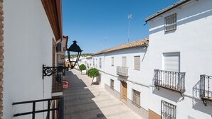 A narrow street with white buildings, a street lamp, and a small tree. - Alojamiento Rural Villa Calatrava Santiago de Calatrava by Ruralidays (Jaén)