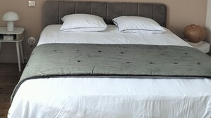 A bedroom with a bed, bedside table, lamp, and a small decorative item. - Quiet little haven 5 kms from the port of La Rochelle  (Dompierre-sur-Mer)