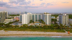 A coastal resort with high-rise buildings, a sandy beach, and a view of the city skyline. - Luxurious 3/3 Ocean View Condo 1413 - Located at 1 Hotel & Homes South Beach (Miami Beach)