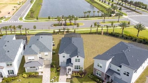 Zona residencial con tres casas, una carretera y un cuerpo de agua.