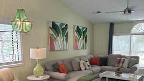 Una sala de estar con sofá, sillón, mesa de centro y elementos decorativos.