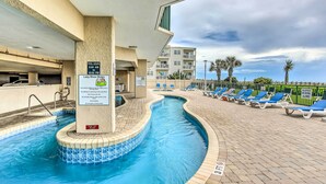 A pool area with a sign indicating pool hours and a 'Keep Off Island' sign. - Oceanfront Beach Condo w/ Stunning Views! (North Myrtle Beach)