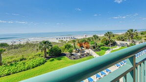 A resort view with a beach, palm trees, and a playground. - Oceanfront Beach Condo w/ Stunning Views! (North Myrtle Beach)
