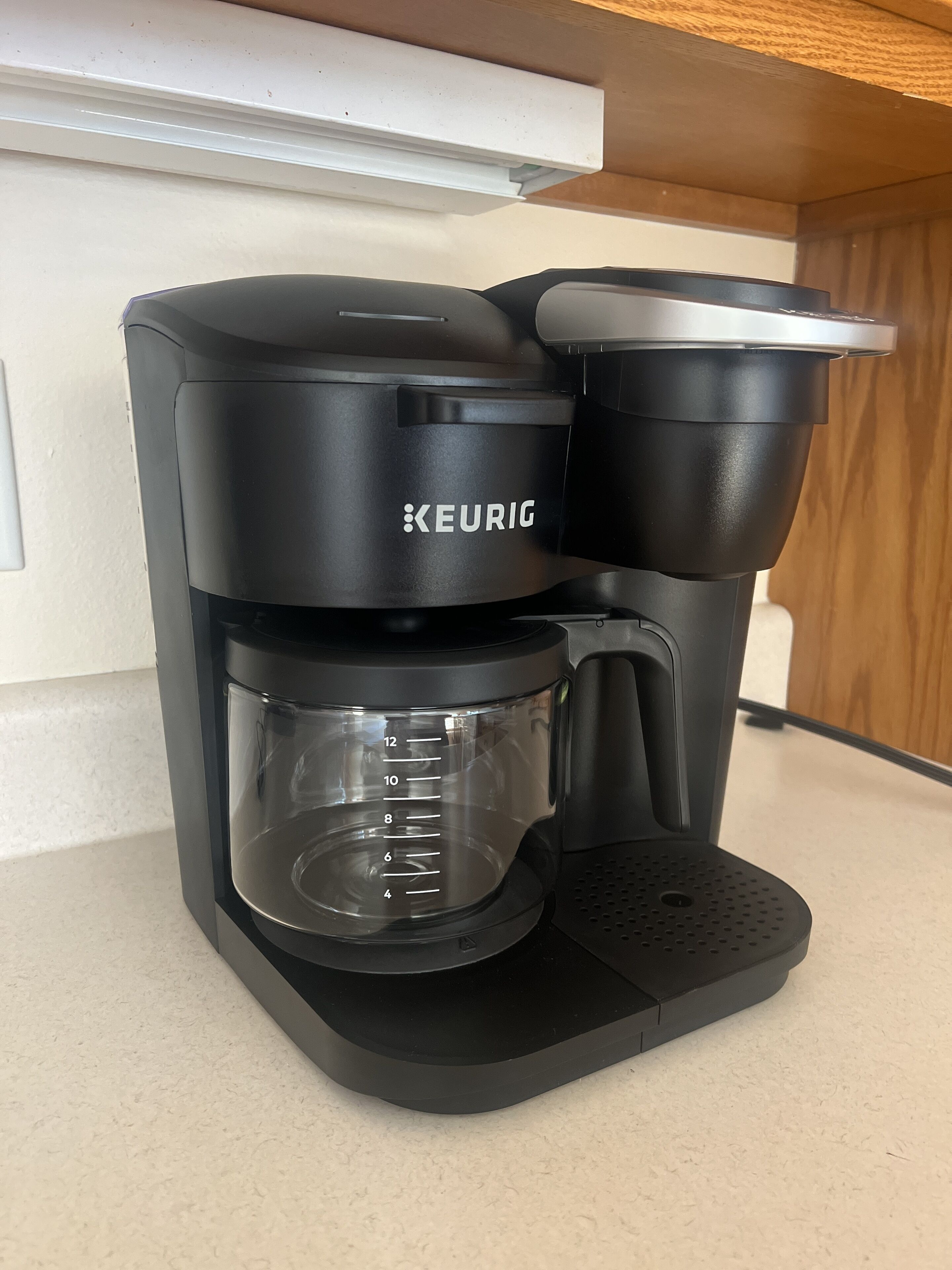 Eine Keurig-Kaffeemaschine mit Klarglasbehälter und Kapselhalter.