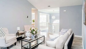 Un salon spacieux doté d’un ventilateur de plafond, d’une table basse et d’un canapé.