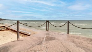 A concrete viewing platform with a rope barrier, overlooking a beach and ocean. - Waterfront Lake Huron Home - Private Beach! (Tawas City)