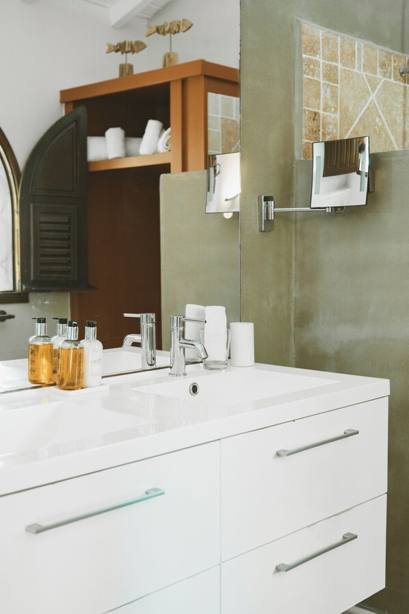 A modern bathroom with a white vanity, two sinks, and a large mirror.