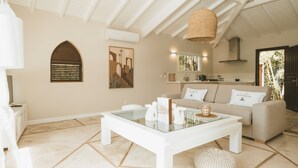 Una sala de estar moderna con una mesa de centro de vidrio, un sofá y un comedor.