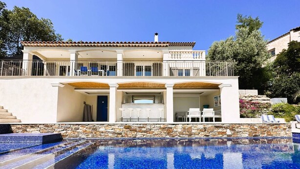 Una casa de dos pisos con piscina delantera.