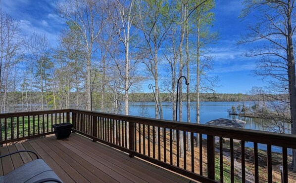 Enjoy serene lake views from this outdoor deck surrounded by trees.