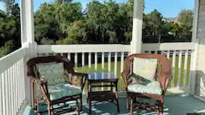 A covered porch with a view of trees and a body of water. - K4 Gulf Shores Vacation Getaway II (Gulf Shores)