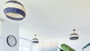 Un soggiorno moderno con un divano blu, un tavolino rotondo e una pianta grande.