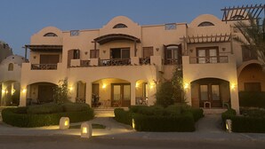 A multi-story building with a symmetrical facade, multiple balconies, and a central entrance. - 2 BR flat overlooking open lagoon and private pool (Red Sea Governorate)