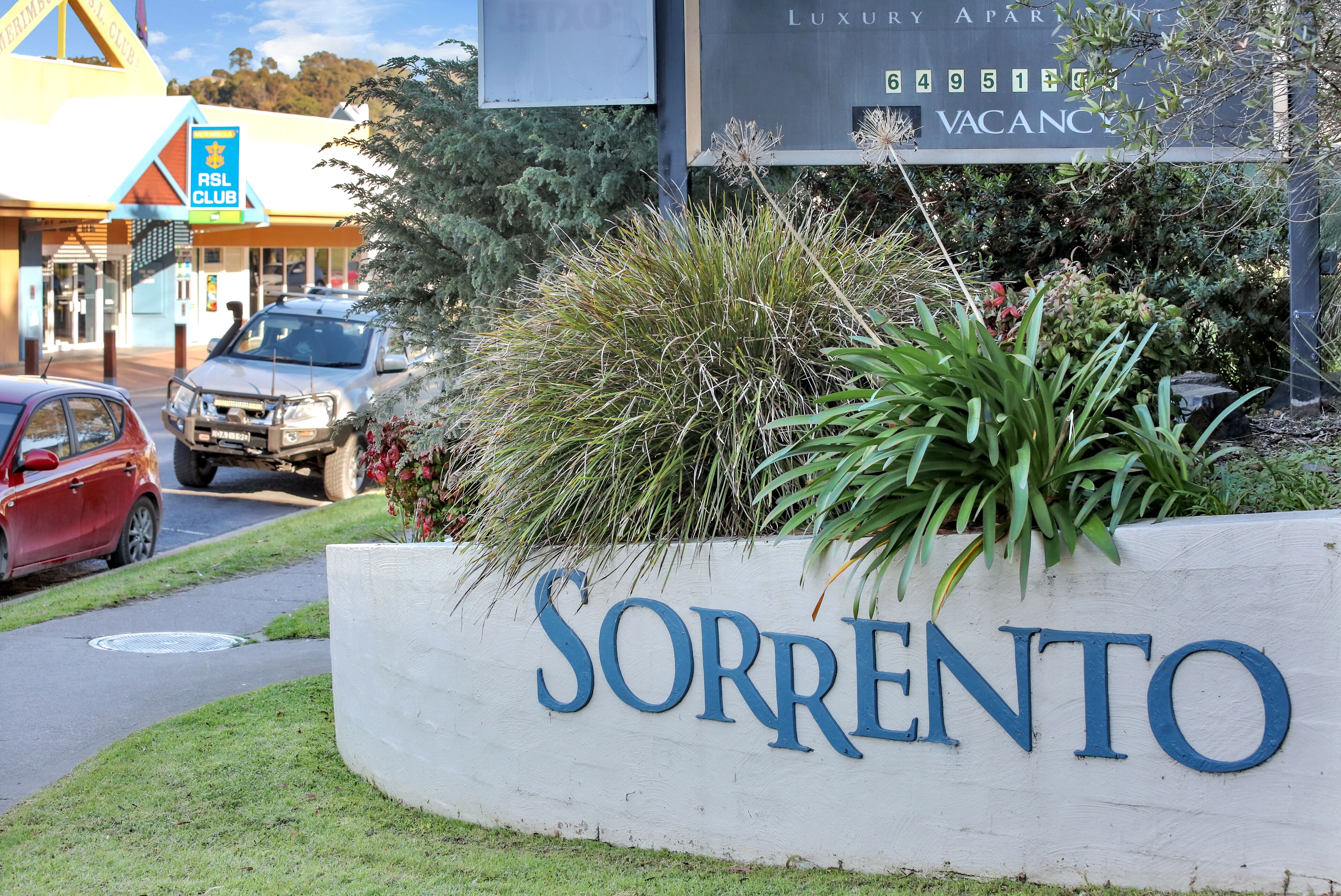 Een bord met 'Sorrento' en op de achtergrond een luxe appartementencomplex.