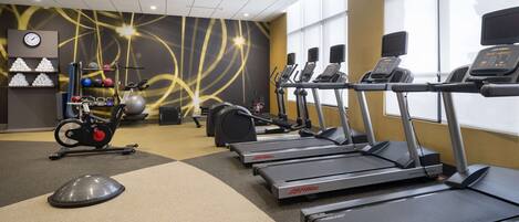 A gym with treadmills, exercise balls, and weights.