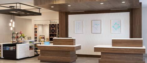 A reception area with wooden reception desks, a minibar, and a TimeShop.