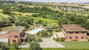 Une villa avec piscine, entourée d’une végétation luxuriante et située dans un paysage vallonné.