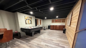 Ein geräumiges Zimmer mit Poolbillard, Holzkästen und einem Essbereich.