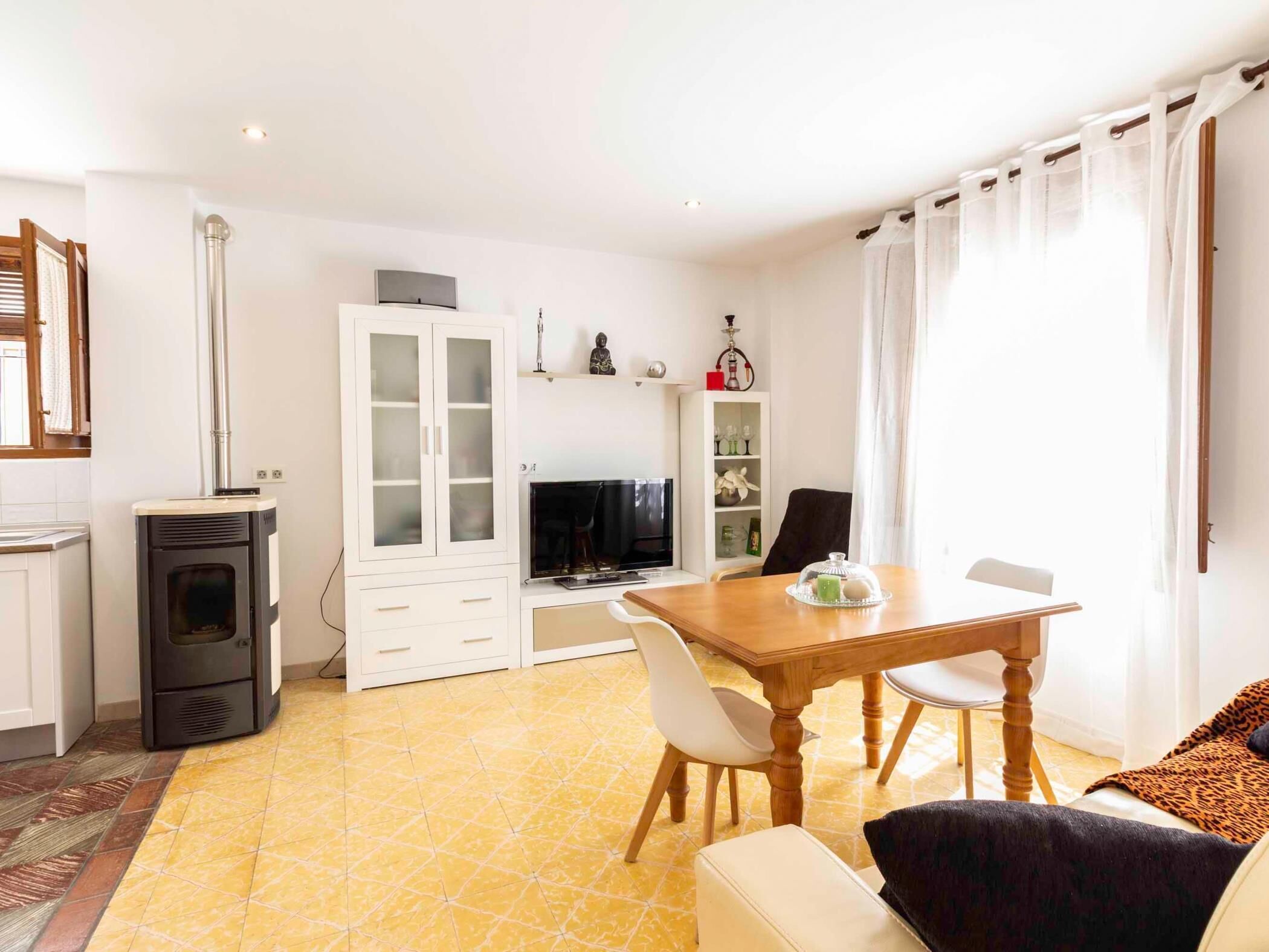 Een moderne woonkamer met een eethoek, een open haard en een televisie.