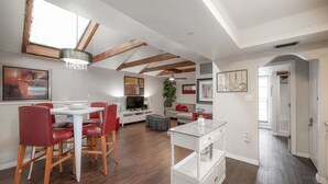 Eine moderne Küche mit Essbereich, Holzbalken und Blick zum Wohnzimmer.