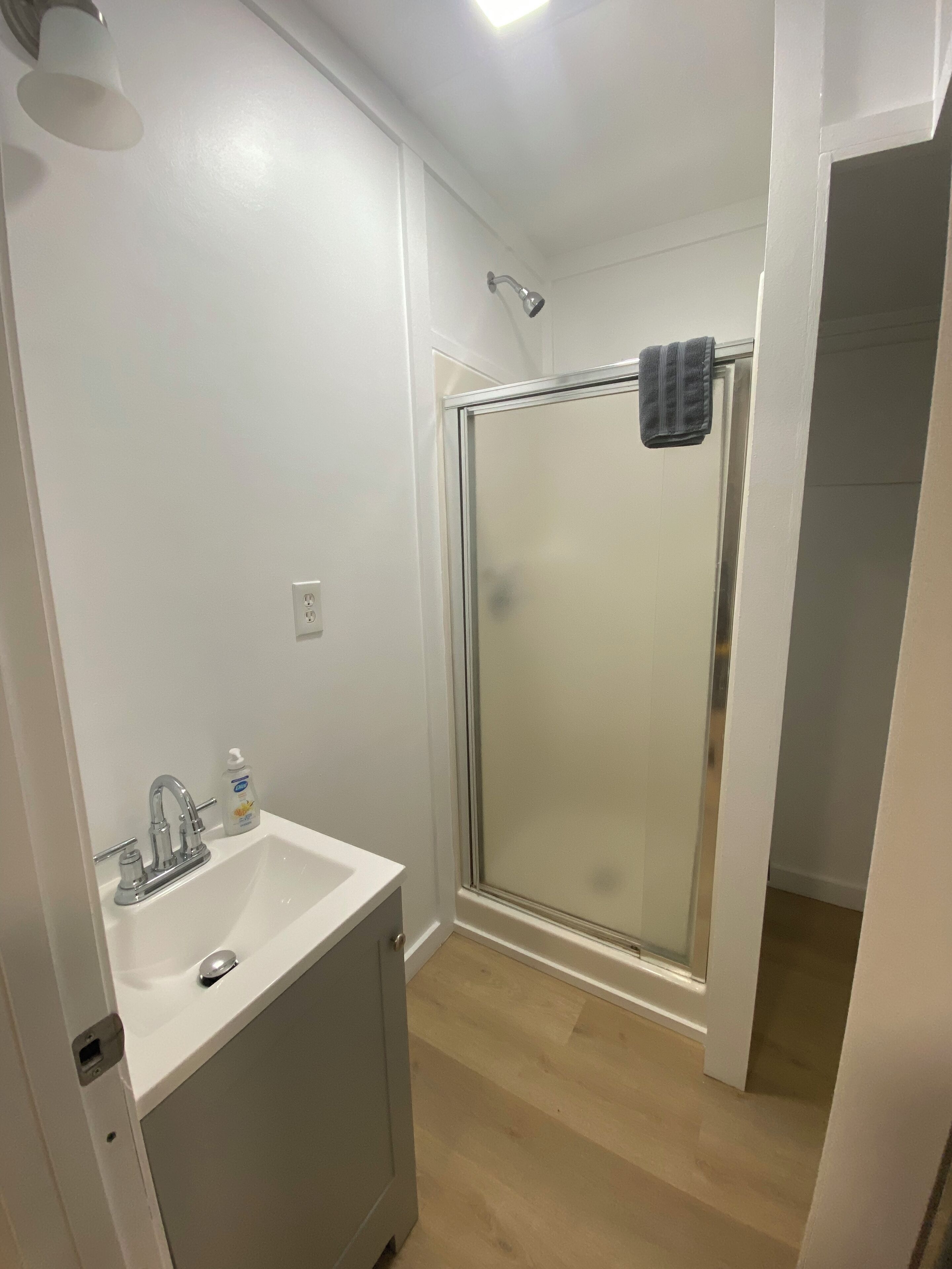 A bathroom with a shower, sink, and toilet.