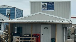 A small boat house with a dock, a table, chairs, and a sign advertising catfish house boat rental. - Catfish house boat for rent, sleeps 8,Ice machine. perfect place to fish 🐠  (Venice)