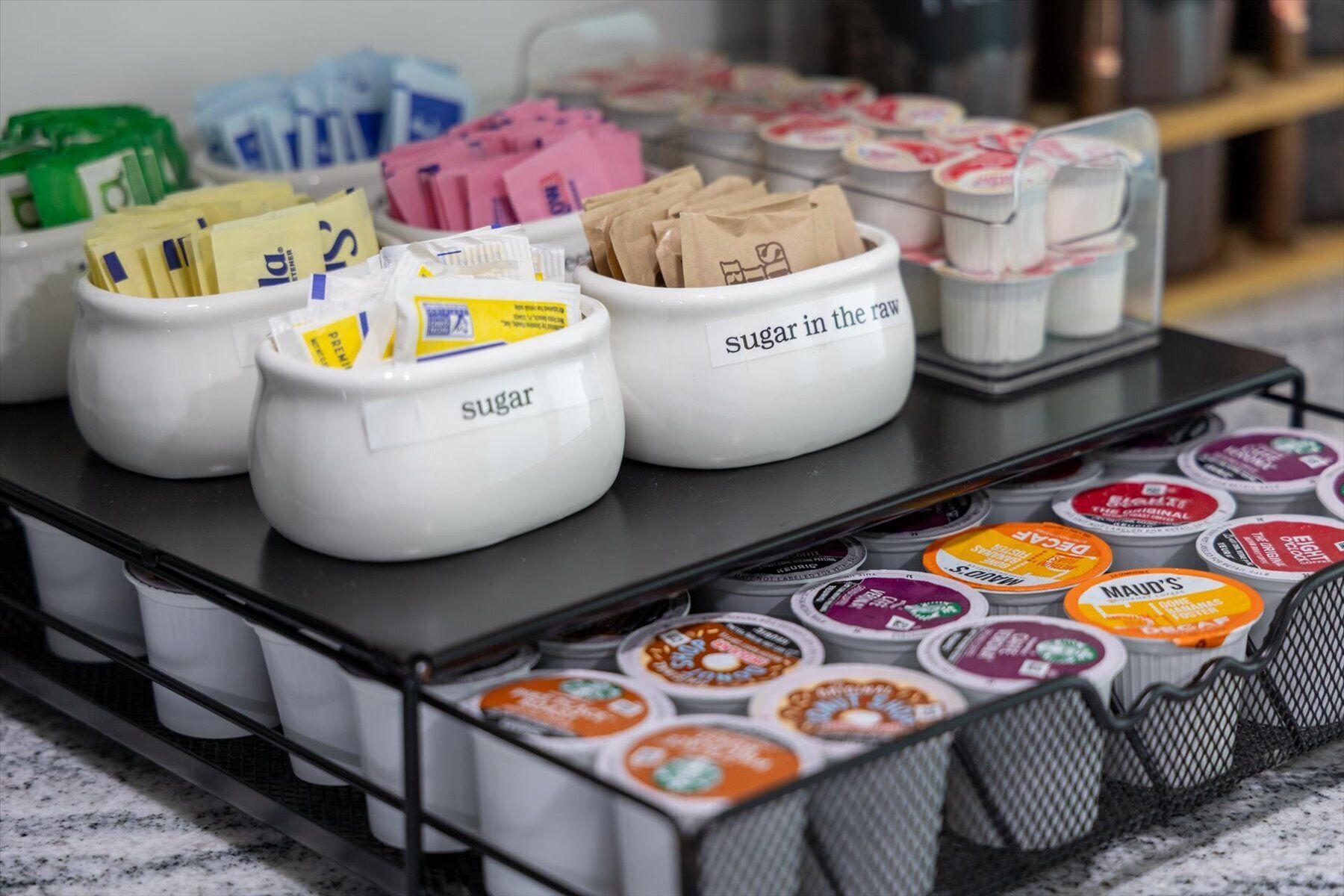 A display of sugar packets and coffee pods on a tray.