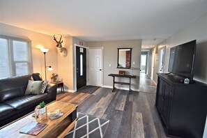 Relax in this stylish living room with a comfortable sofa, coffee table, and large mirror.