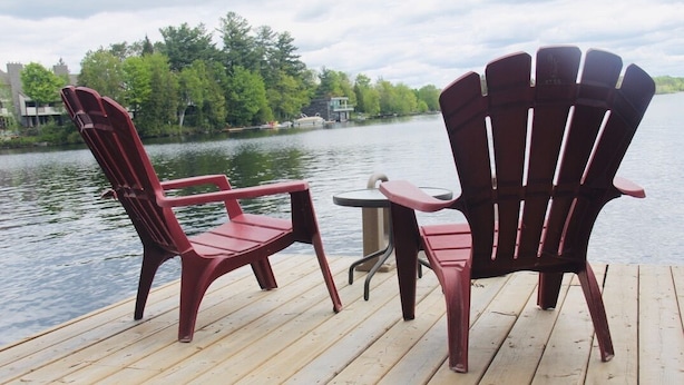 A wooden deck with two Adirondack chairs and a small round table. - Beautiful lakefront retreat, 4 bedroom, sleeps 8 (Huntsville)