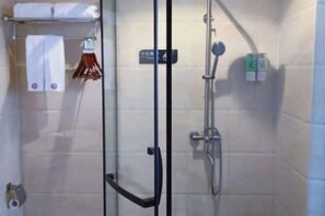 A glass-enclosed shower area with a towel rack and a sign indicating the shower direction. - Bengenei Hotel (Qiongzhong)