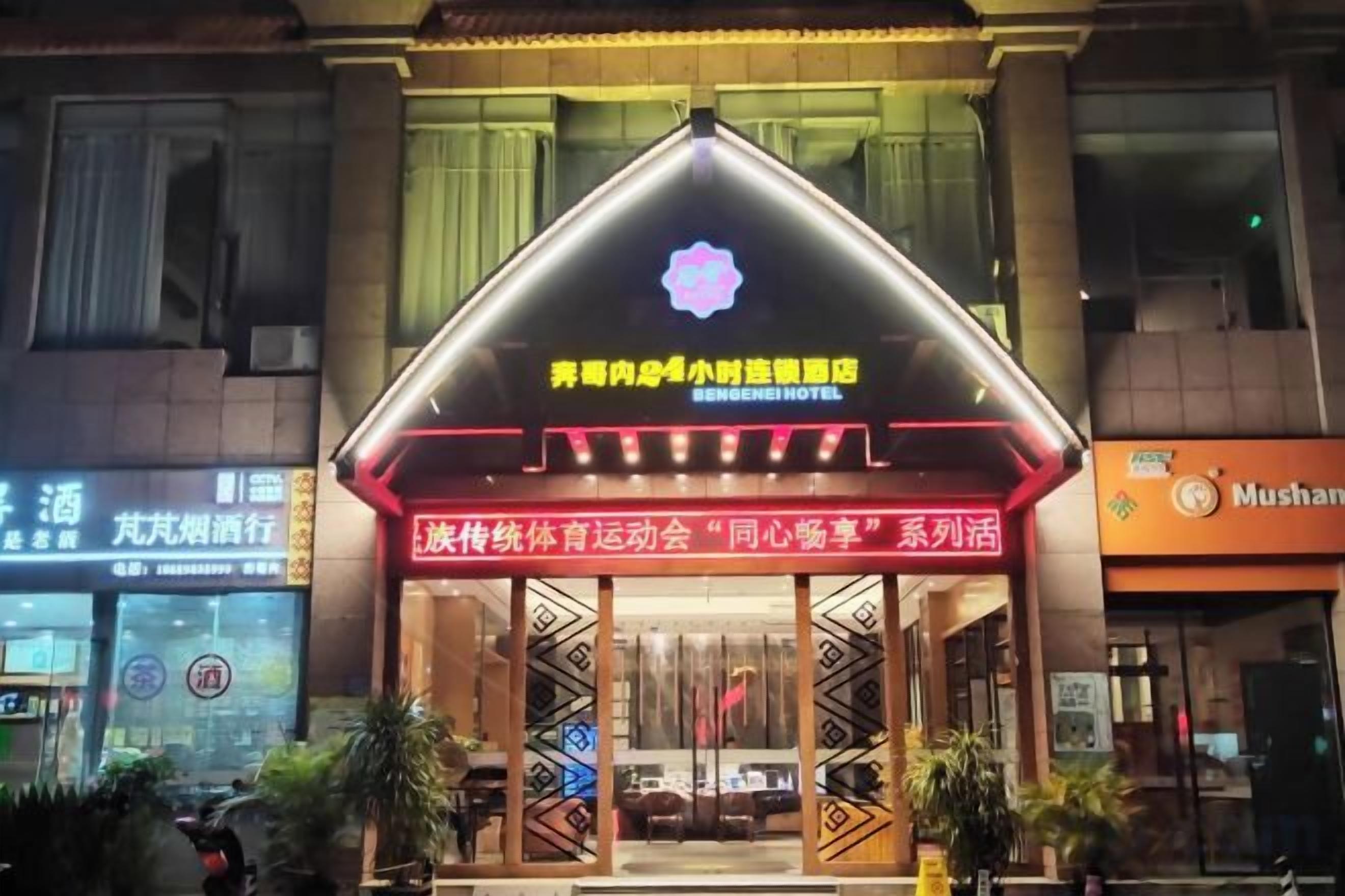 A hotel entrance with a traditional Chinese architectural style, featuring a prominent red and gold color scheme and a signboard with Chinese characters.