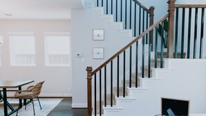Una escalera con barandillas de madera y peldaños blancos que llevan a una plataforma.
