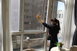 Una persona limpiando un ventanal con un exprimidor de goma.