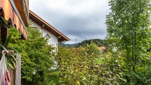 Un bâtiment blanc avec un toit en bois, entouré d’une végétation luxuriante et agrémenté d’un hamac.
